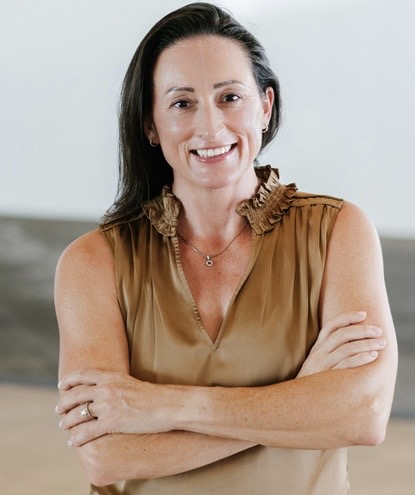 Lisa, founder, smiling with arms folded